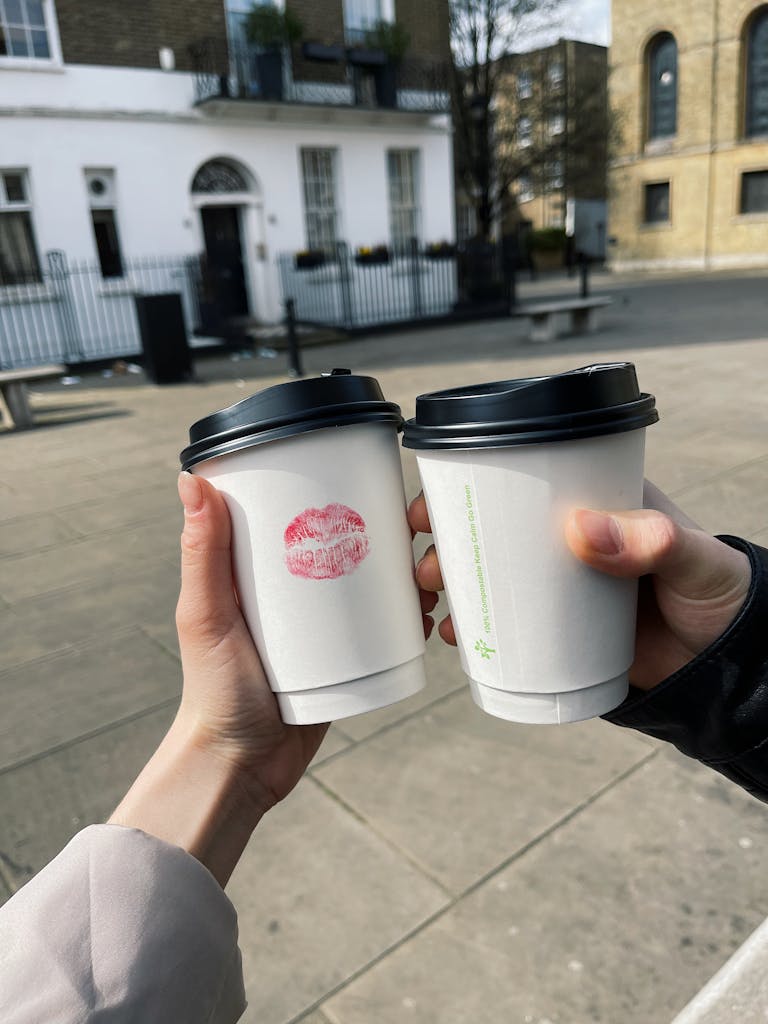 Crop couple clinking with coffee cups